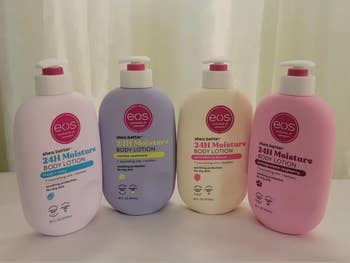 Four EOS 24H Moisture Body Lotion bottles successful  assorted  scents, including caller  & cozy, vanilla cashmere, strawberry peach, and pomegranate raspberry