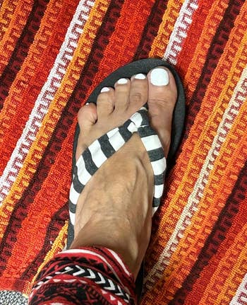 Person's foot wearing a striped flip-flop
