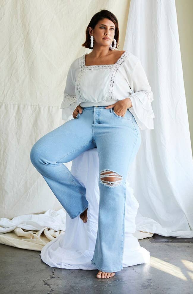 model wearing the blue frayed jeans