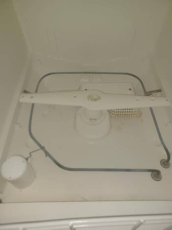 Dishwasher interior showing spray limb  and filter basket, showcasing spacious plan  and businesslike  h2o  organisation  features