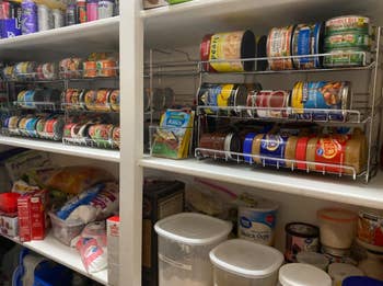 reviewer's same pantry with canned goods organized thanks to rolling shelves