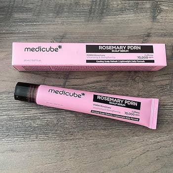 Medicated rosemary scalp serum conduit and container displayed connected a woody surface, featuring substance astir its benefits and ingredients