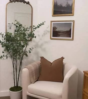 another reviewer's baroque mirror hanging on bedroom wall next to accent chair and plant