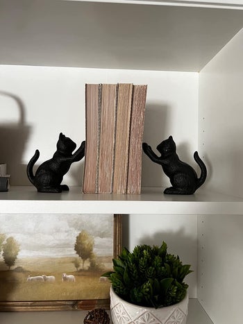 reviewer photo of the bookends, which look like two black cats standing on their hind legs posed like they're scratching something