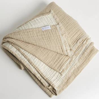 the folded blanket showing a darker beige side and lighter tan side