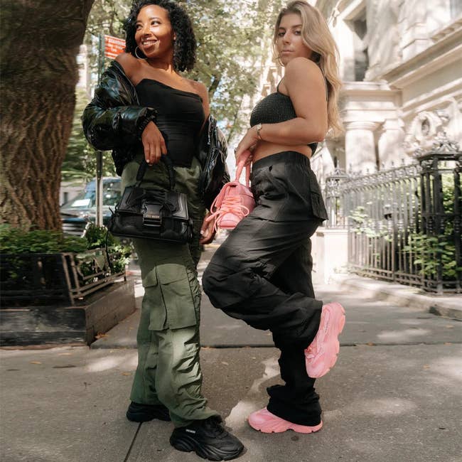 two models wearing pink and black sneakers