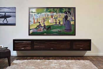 A living room with a TV displaying Georges Seurat's 