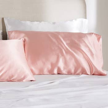 The pink satin cases on pillows on a bed