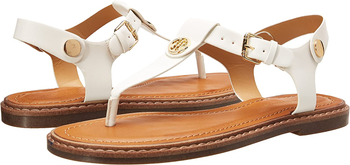 Side view of white t-strap sandals on a white background