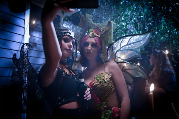 Two women dressed in fairy halloween costumes taking a selfie outside