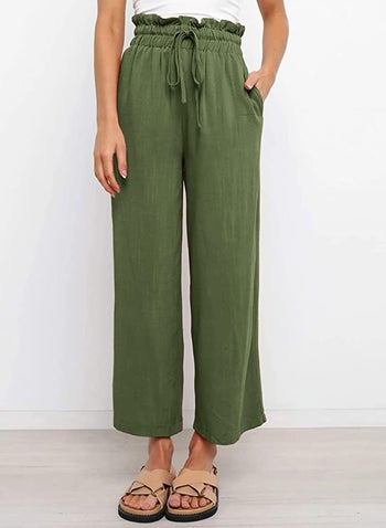 Model in a pair of high waited loose green elastic waistband pants