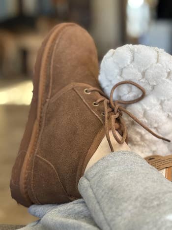 Cozy suede slipper with laces connected  a person's foot, resting connected  a plush broad  successful  a relaxed setting. Ideal for comfy  at-home wear