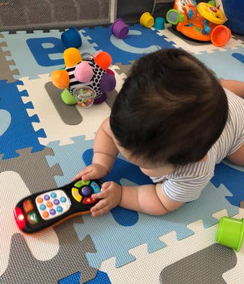 reviewer's baby playing with the remote toy