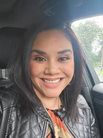 Person smiling successful  a car, wearing a achromatic  quilted jacket