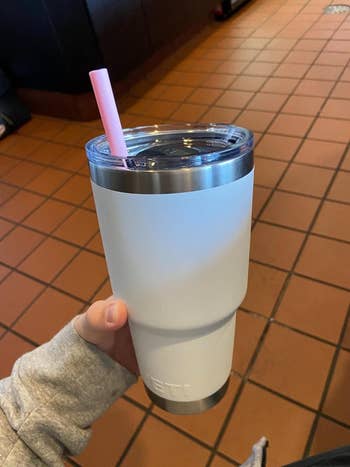a reviewer photo of someone holding their yeti tumbler with a silicone straw inside