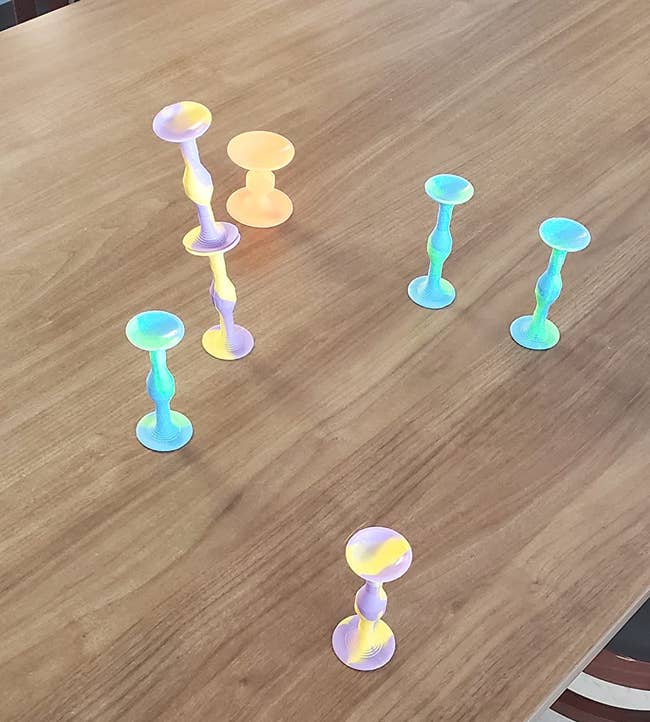 Colorful suction cupful toys attached to a woody table, viewed successful location setting