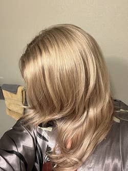 the same reviewer with shiny blonde hair after using the hair treatment