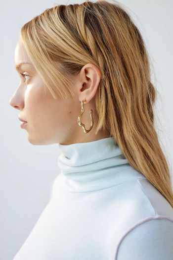 a model wearing the gold earrings
