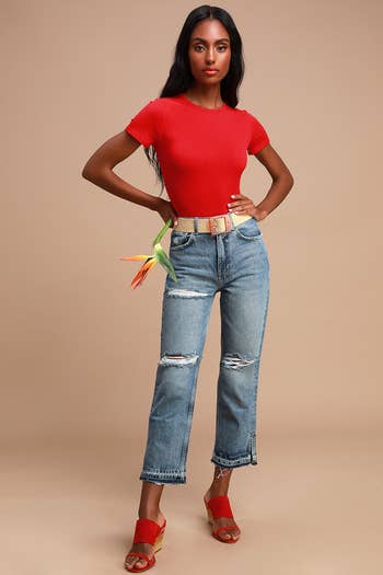model in solid red version tucked into jeans