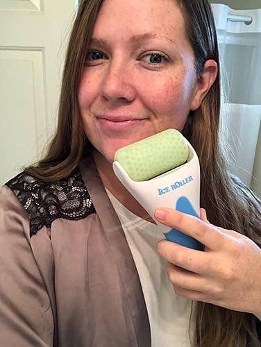 Person smiling portion holding an crystal roller to their face, suggesting a refreshing skincare routine