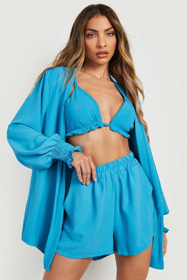 model wearing blue bralette, long sleeve top, and oversized shorts
