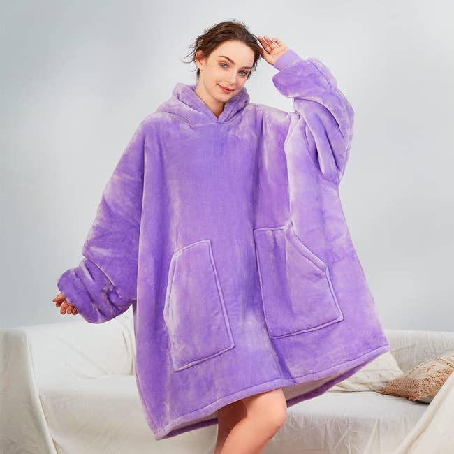 Person wearing oversized, cozy fleece blanket hoodie with large front pockets