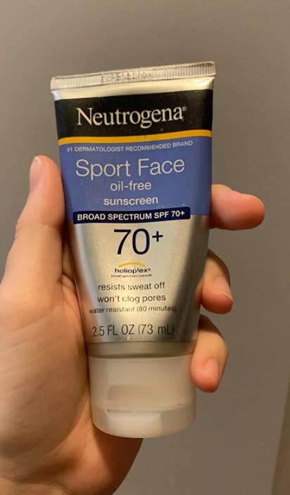 hand holding the tube of sunscreen