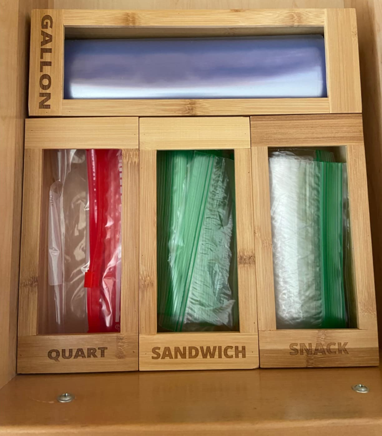 a reviewer photo of the sandwich bag organizer in a drawer filled with the appropriate size bag