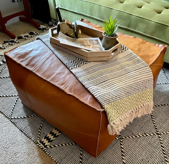 the large brown leather ottoman