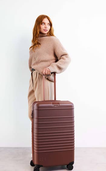 Model posing with the maple checked suitcase