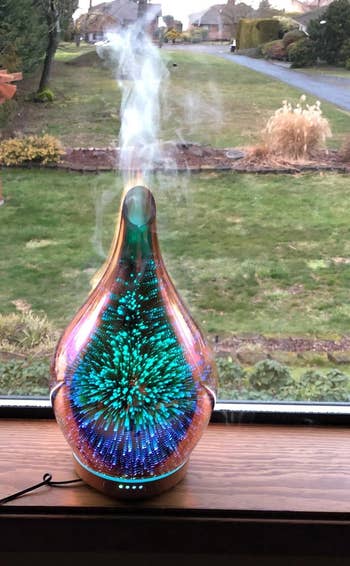 Reviewer pic of the same type of diffuser but showing green and blue lighting and putting out a ton of mist at the top
