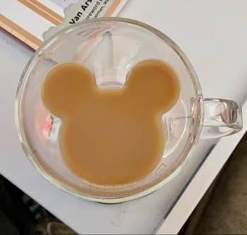 glass cup with inner walls shaped like mickey's head holding coffee 