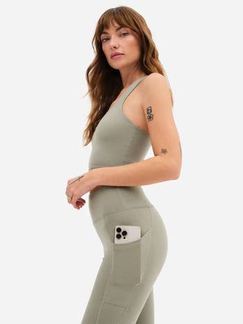 Model showing the side pocket holding a phone in the leggings 