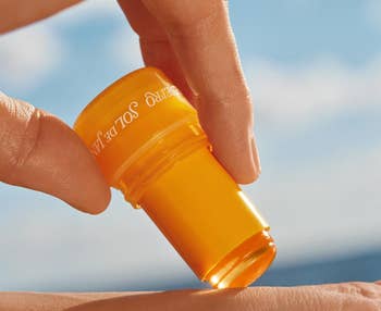 Hand holding a twist-up skincare instrumentality with the statement