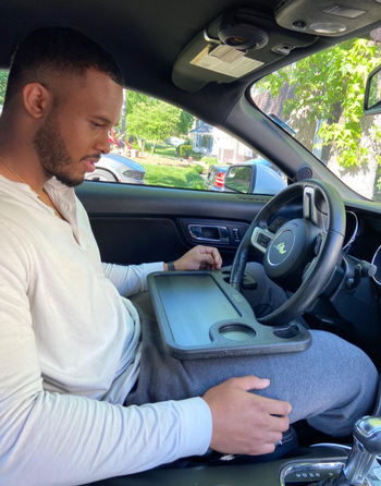 reviewer sitting at the wheel with tray installed on it