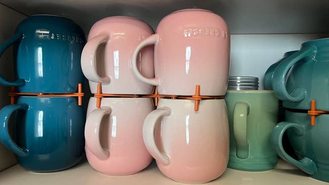 Stacked ceramic mugs with handles hooked together for easy storage