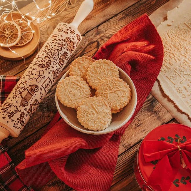 Christmas rolling pin next to baked cookies