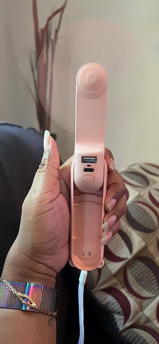A reviewer using the pink portable fan