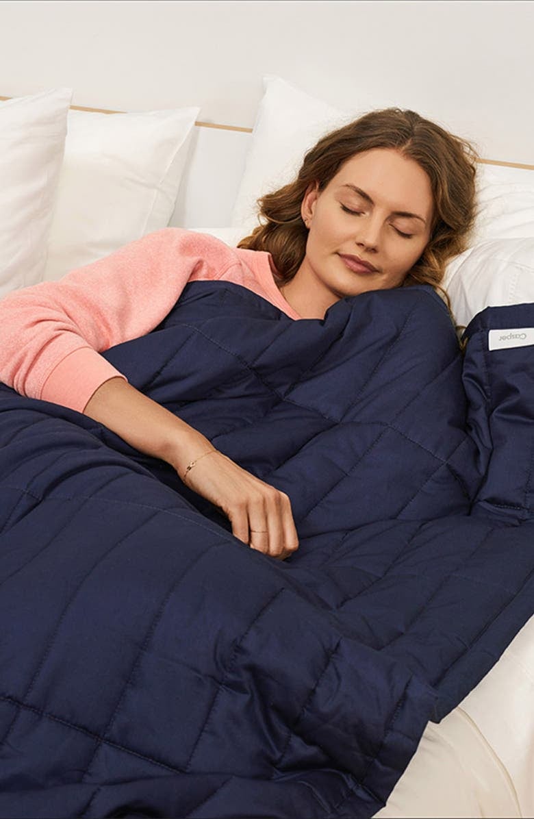 model with the dark blue quilted blanket over them