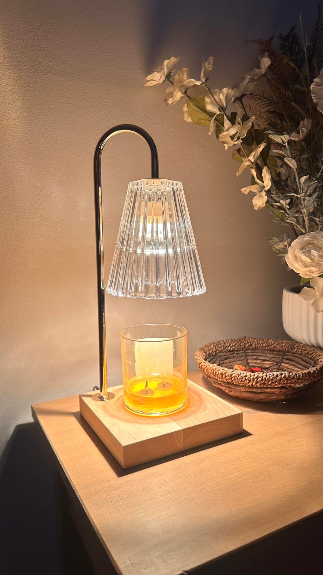 Stylish lamp with solid  shadiness  connected  a woody  array  adjacent  to a candle holder and decorative flowers successful  a vase
