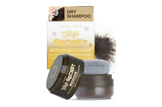 Tap Secret dry shampoo in dark brown with an applicator, beside a spilled powder. Packaging detail in background
