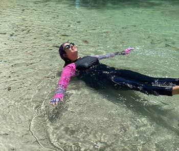 reviewer wearing black leggings while lounging in lake water