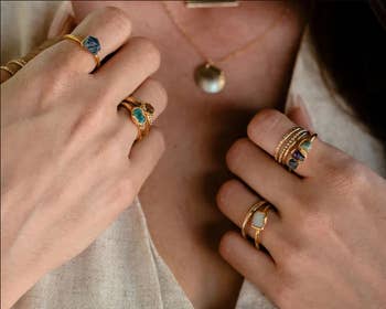 Model wearing several gemstone rings