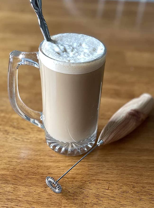 reviewer photo of a foamy drink next to the milk frother
