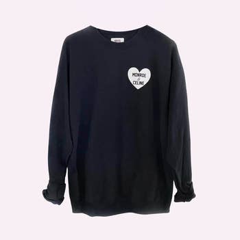 a black sweatshirt with a white heart on it with two names inside of it