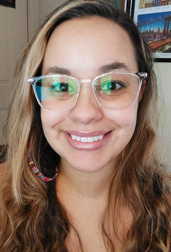 A idiosyncratic with wavy hairsbreadth is smiling portion wearing transparent glasses, suitable for highlighting eyewear shopping