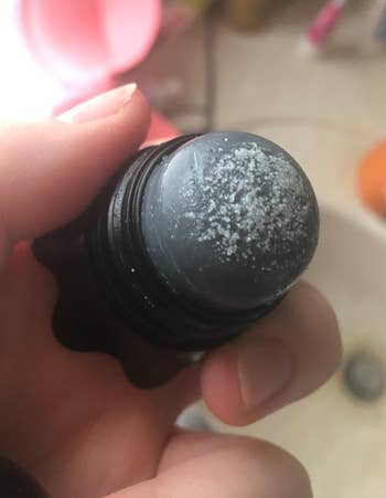 another reviewer holding scrub stick with black heads and white heads on it