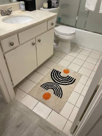 Bathroom with a rug with a geometric design by the sink