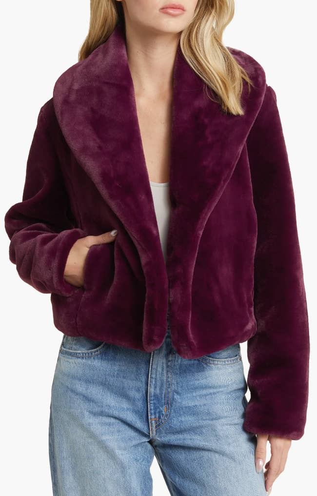 model wearing faux fur coat in a berry color