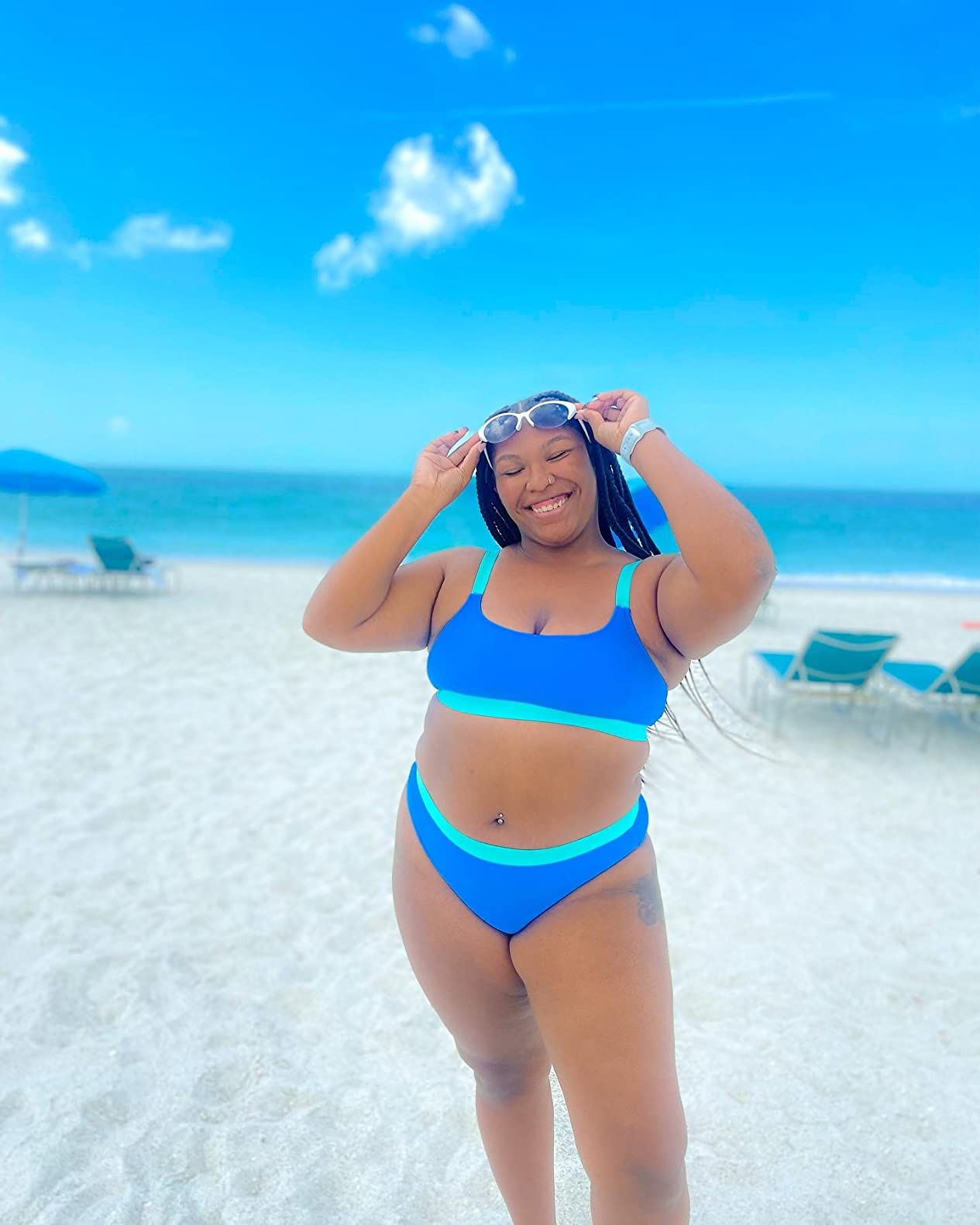 curvy reviewer wearing the suit with goggles on a beach